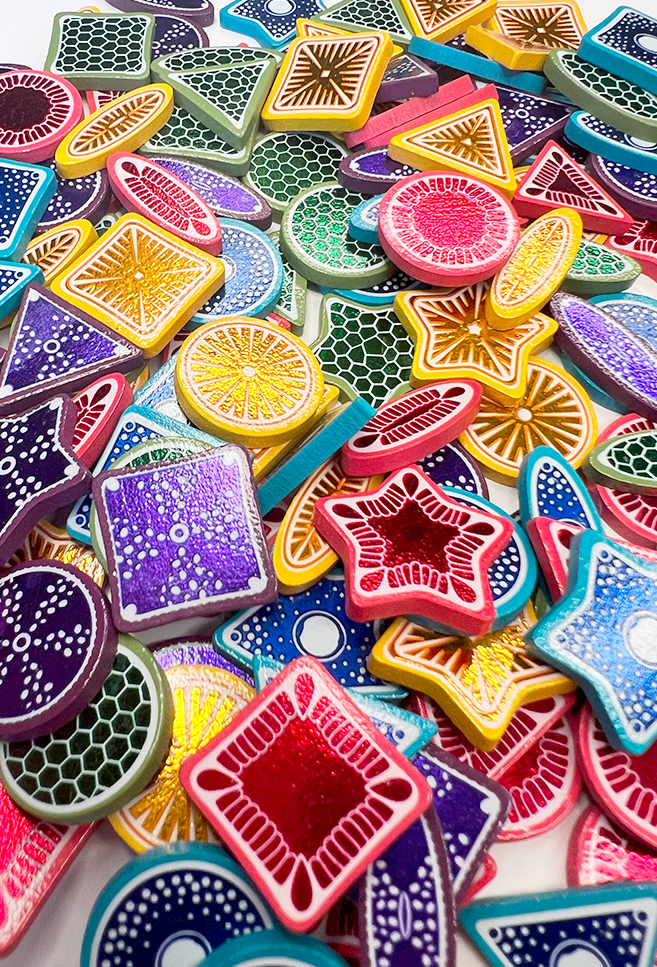 Photo close up  blue, pink, yellow, purple, and green wooden diatom tiles with metalic foil prints